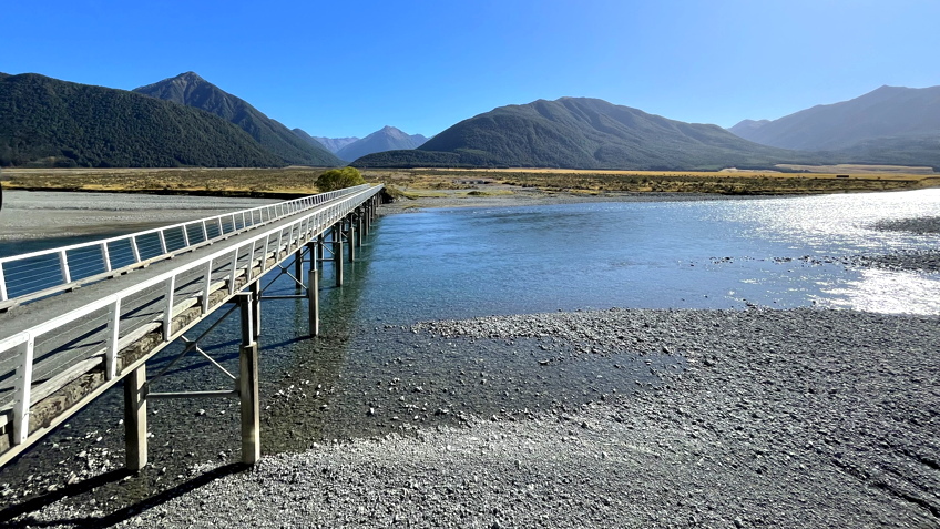 TranzAlpine rail journey following a river valley in New Zealand South Island